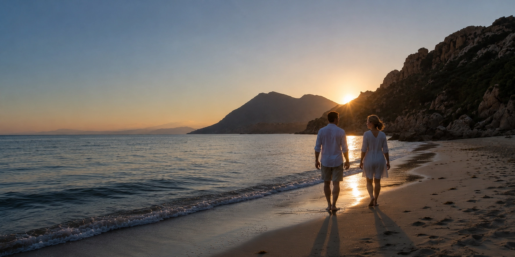 Couple walking on the beach at sunset